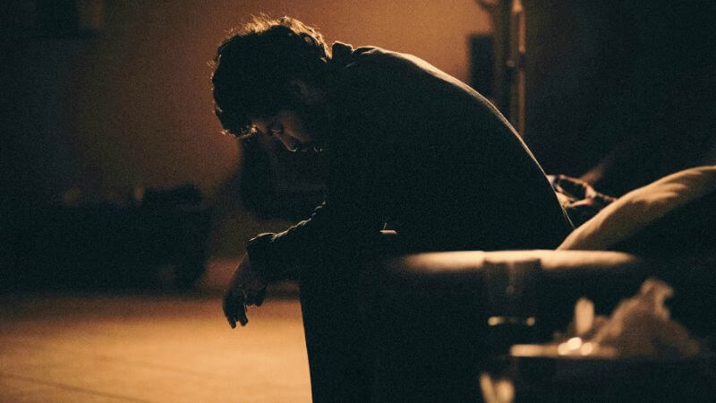 ソファに座り落ち込む男