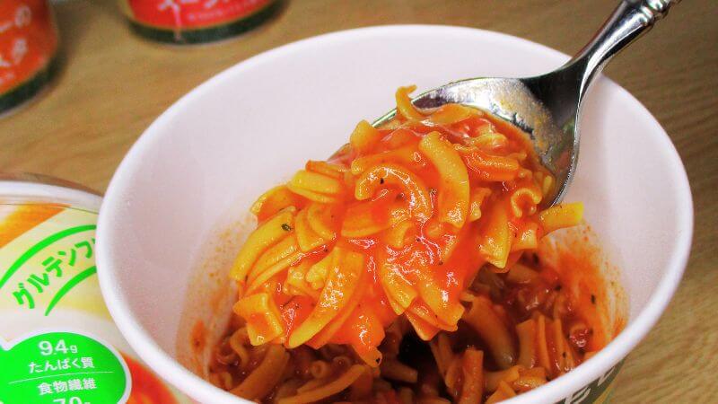 完熟トマトのスープパスタをスプーンですくう