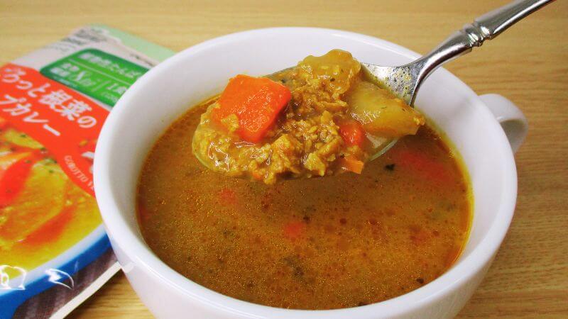 カゴメプラントベースごろっと根菜のスープカレーをスプーンですくう