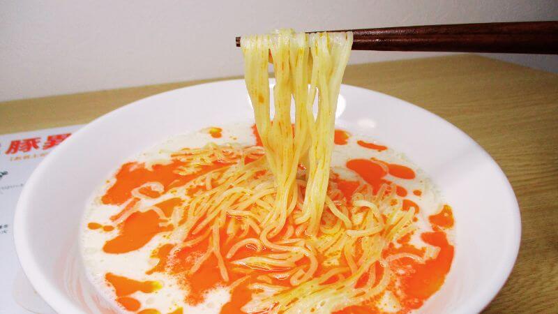 めん工房久保田ビーガンラーメン豚異（とんこと）の麺を箸で持ち上げる